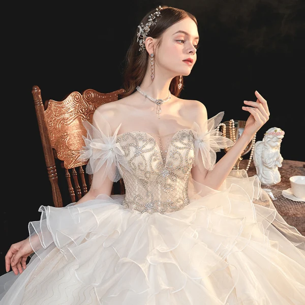 Schöne Champagner Organza Hochzeits Brautkleider / Hochzeitskleider 2020 Ballkleid Off Shoulder Kurze Ärmel Rückenfreies Perlenstickerei Strass Kathedrale Schleppe Rüschen