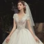 Romantique Champagne La Mariée Robe De Mariée 2020 Robe Boule Transparentes Col v profond Manches Courtes Dos Nu Appliques En Dentelle Perlage Glitter Tulle Cathedral Train Volants