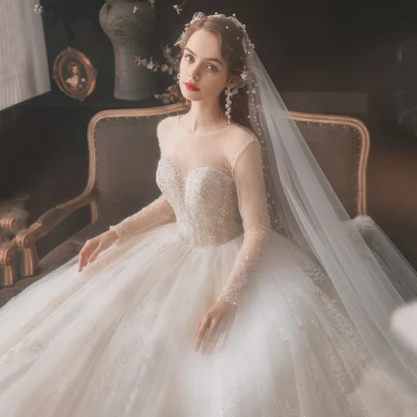 Romantic Champagne See-through Bridal Wedding Dresses 2020 Ball Gown Scoop Neck Long Sleeve Backless Appliques Lace Beading Glitter Tulle Cathedral Train Ruffle