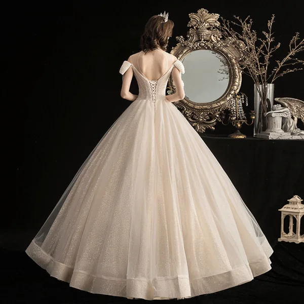 Élégant Champagne Robe De Mariée 2020 Robe Boule Transparentes Encolure Dégagée Noeud Manches Courtes Dos Nu Perlage Gland Glitter Tulle Longue Volants