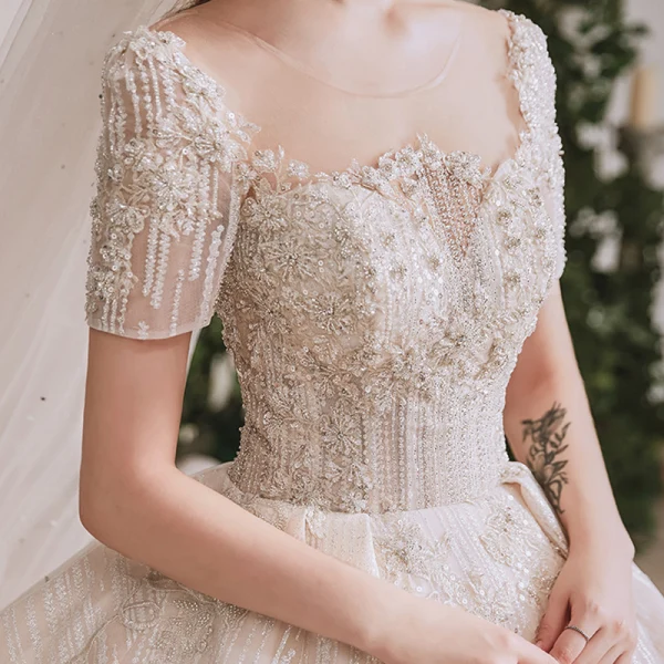 Luxe Champagne La Mariée Robe De Mariée 2020 Robe Boule Transparentes Encolure Dégagée Manches Courtes Dos Nu Fait main Perlage Paillettes Glitter Tulle Cathedral Train Volants