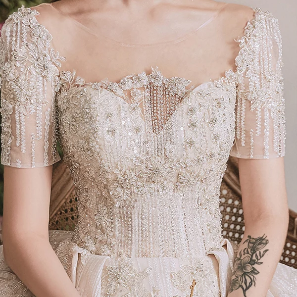 Luxe Champagne La Mariée Robe De Mariée 2020 Robe Boule Transparentes Encolure Dégagée Manches Courtes Dos Nu Fait main Perlage Paillettes Glitter Tulle Cathedral Train Volants