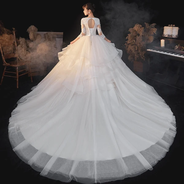 Illusion Champagne La Mariée Robe De Mariée 2020 Robe Boule Transparentes Col v profond Manches Longues Dos Nu Appliques En Dentelle Perlage Noeud Ceinture Glitter Tulle Cathedral Train Volants