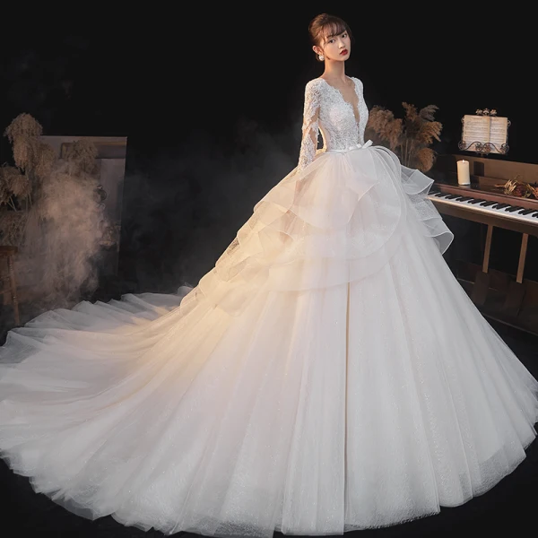 Illusion Champagne La Mariée Robe De Mariée 2020 Robe Boule Transparentes Col v profond Manches Longues Dos Nu Appliques En Dentelle Perlage Noeud Ceinture Glitter Tulle Cathedral Train Volants