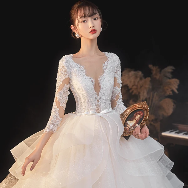Illusion Champagne La Mariée Robe De Mariée 2020 Robe Boule Transparentes Col v profond Manches Longues Dos Nu Appliques En Dentelle Perlage Noeud Ceinture Glitter Tulle Cathedral Train Volants