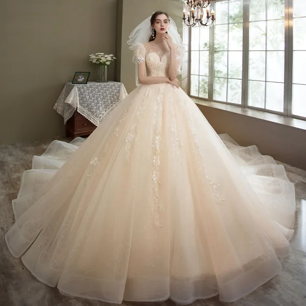 Romantique Champagne La Mariée Robe De Mariée 2021 Robe Boule Transparentes Encolure Dégagée Gonflée Manches Courtes Dos Nu Appliques En Dentelle Perlage Paillettes Glitter Tulle Cathedral Train Volants