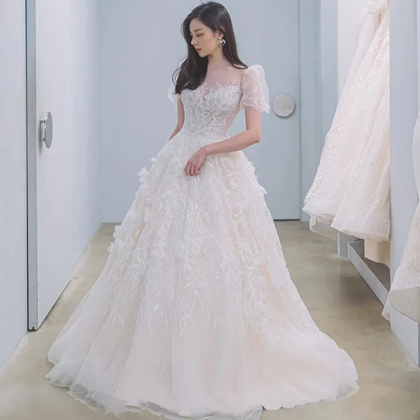 Illusion Champagne La Mariée Robe De Mariée 2021 Princesse Transparentes Encolure Dégagée Gonflée Manches Courtes Dos Nu Appliques En Dentelle Perlage Tribunal Train Volants