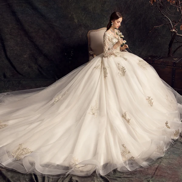 Charmant Champagner Brautkleider / Hochzeitskleider 2019 A Linie Tiefer V-Ausschnitt Perlenstickerei Pailletten Spitze Blumen Lange Ärmel Rückenfreies Kapelle-Schleppe