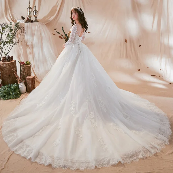 Chic / Belle Blanche Transparentes Robe De Mariée 2018 Robe Boule Encolure Dégagée Manches Longues Dos Nu Appliques En Dentelle Perle Volants Royal Train