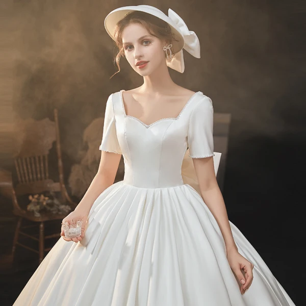 Haut de Gamme Élégant Ivoire Satin Robe De Mariée 2021 Robe Boule Perle Encolure Carrée Manches Courtes Dos Nu Noeud Royal Train Mariage
