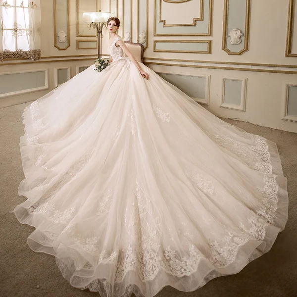 Elegante Ivory / Creme Durchsichtige Brautkleider 2018 A Linie Rundhalsausschnitt Ärmel Rückenfreies Applikationen Mit Spitze Perle Kristall Perlenstickerei Kapelle-Schleppe Rüschen
