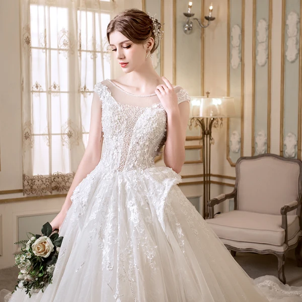 Elegante Ivory / Creme Durchsichtige Brautkleider 2018 A Linie Rundhalsausschnitt Ärmel Rückenfreies Applikationen Mit Spitze Perle Kristall Perlenstickerei Kapelle-Schleppe Rüschen