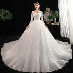 Schöne Ivory Creme Brautkleider Hochzeitskleider 2020 Ballkleid V Ausschnitt Durchbohrt Lange Ärmel Rückenfreies Applikationen Spitze Kathedrale Schleppe Rüschen