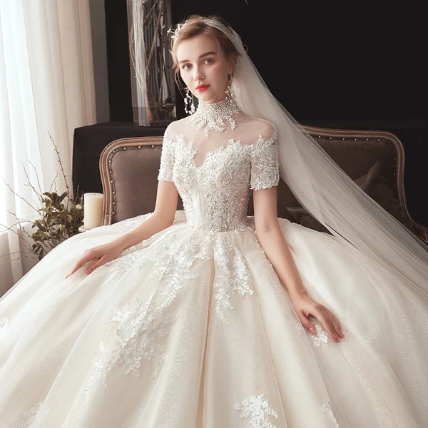 Vintage / Originale Champagne Transparentes Robe De Mariée 2020 Robe Boule Col Haut Manches Courtes Dos Nu Glitter Tulle Appliques En Dentelle Perlage Chapel Train Volants