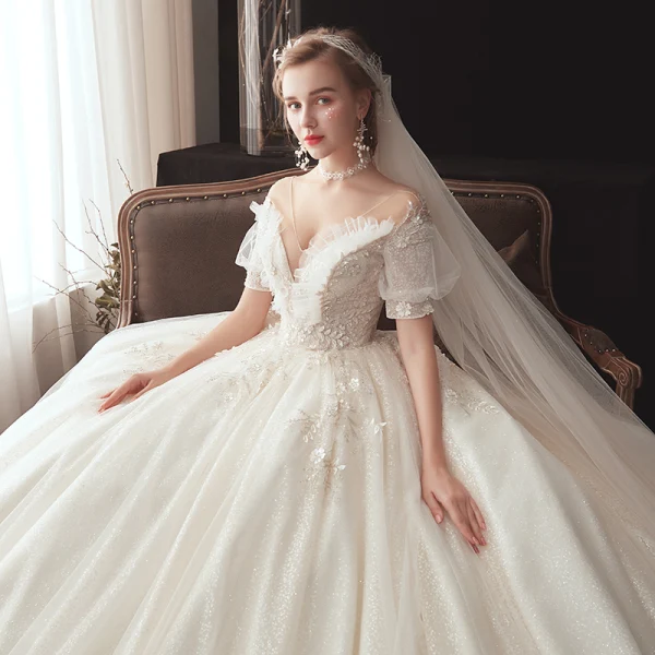 Style Victorien Champagne Transparentes Robe De Mariée 2020 Robe Boule V-Cou Gonflée Manches Courtes Dos Nu Glitter Tulle Appliques En Dentelle Perlage Chapel Train Volants