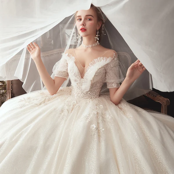 Style Victorien Champagne Transparentes Robe De Mariée 2020 Robe Boule V-Cou Gonflée Manches Courtes Dos Nu Glitter Tulle Appliques En Dentelle Perlage Chapel Train Volants
