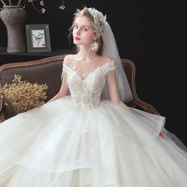 Romantisch Ivory / Creme Hochzeits Brautkleider / Hochzeitskleider 2020 Ballkleid Durchsichtige Rundhalsausschnitt Kurze Ärmel Rückenfreies Applikationen Spitze Perlenstickerei Quaste Kathedrale Schleppe Fallende Rüsche