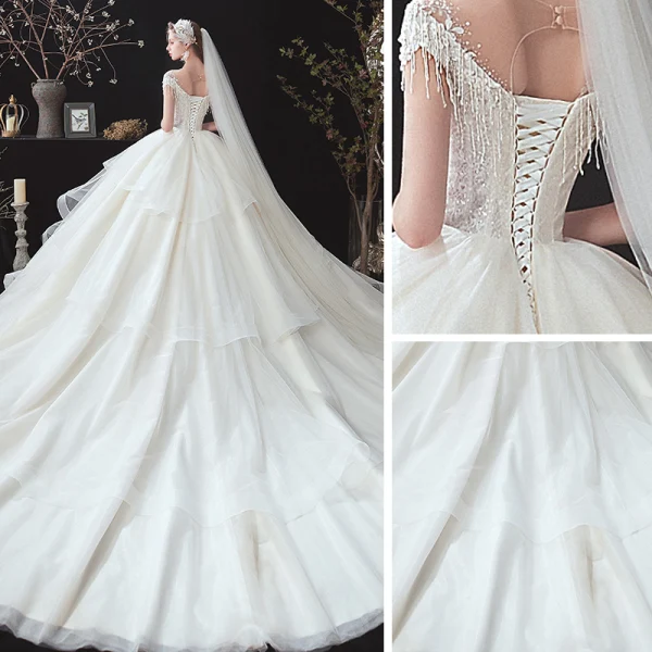Romantisch Ivory / Creme Hochzeits Brautkleider / Hochzeitskleider 2020 Ballkleid Durchsichtige Rundhalsausschnitt Kurze Ärmel Rückenfreies Applikationen Spitze Perlenstickerei Quaste Kathedrale Schleppe Fallende Rüsche