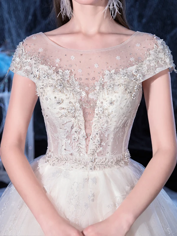 Illusion Ivoire Transparentes La Mariée Robe De Mariée 2020 Princesse Encolure Dégagée Manches Courtes Dos Nu Glitter Tulle Appliques Fleur Perlage Cathedral Train Volants