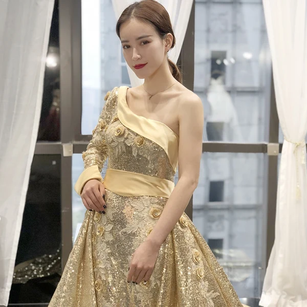 Glitzernden Gold Pailletten Roter Teppich Abendkleider 2023 A Linie One-Shoulder Lange Ärmel Stoffgürtel Applikationen Blumen Perlenstickerei Kapelle-Schleppe Rüschen Rückenfreies