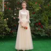 Asequible Elegantes Champán Transparentes Vestidos De Damas De Honor 2019 A-Line / Princess Cinturón Apliques Con Encaje Largos Ruffle Sin Espalda Vestidos para bodas