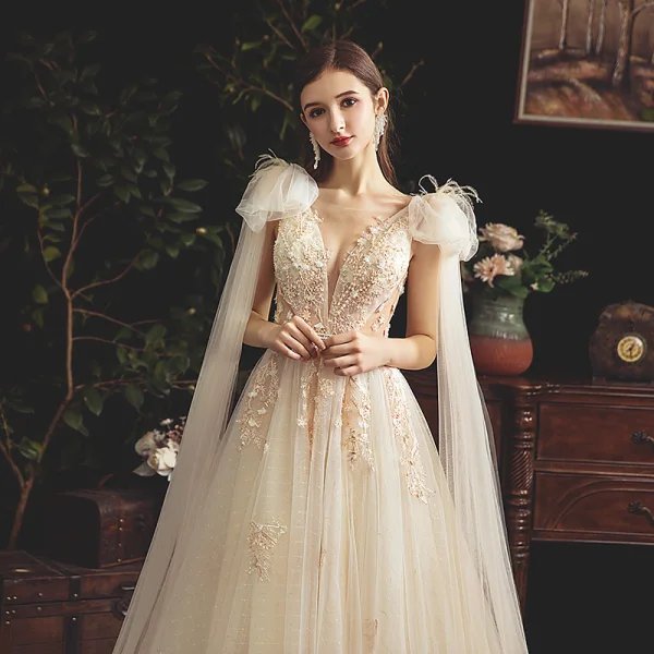 Chic / Belle Champagne Transparentes Robe De Mariée 2019 Princesse Col v profond Sans Manches Dos Nu Appliques En Dentelle Perlage Perle Plumes Ceinture Tribunal Train Volants