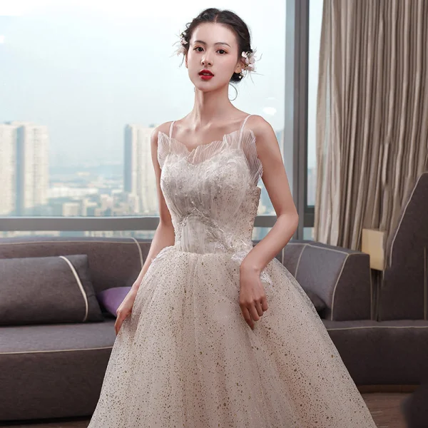 Schöne Champagner Brautkleider / Hochzeitskleider 2019 Empire Spaghettiträger Ärmellos Rückenfreies Applikationen Spitze Perlenstickerei Perle Glanz Tülle Kapelle-Schleppe Rüschen