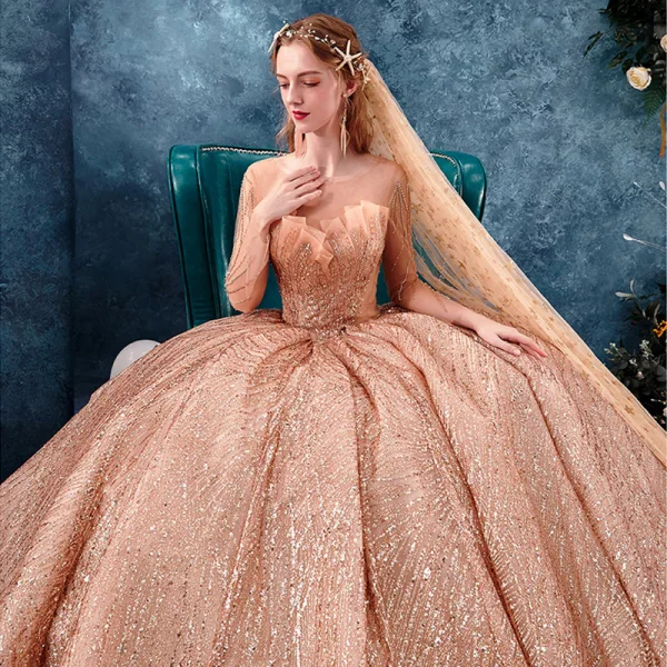 Unique Gold Durchsichtige Brautkleider / Hochzeitskleider 2019 Ballkleid Rundhalsausschnitt Lange Ärmel Rückenfreies Herzförmig Perlenstickerei Glanz Pailletten Kathedrale Schleppe Rüschen