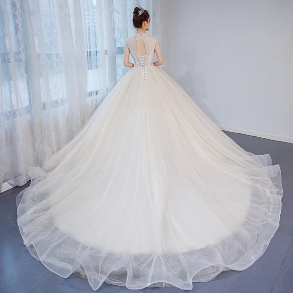 Charmant Champagner Durchsichtige Brautkleider / Hochzeitskleider 2020 Ballkleid Rundhalsausschnitt Ärmel Rückenfreies Perlenstickerei Glanz Tülle Kapelle-Schleppe Rüschen