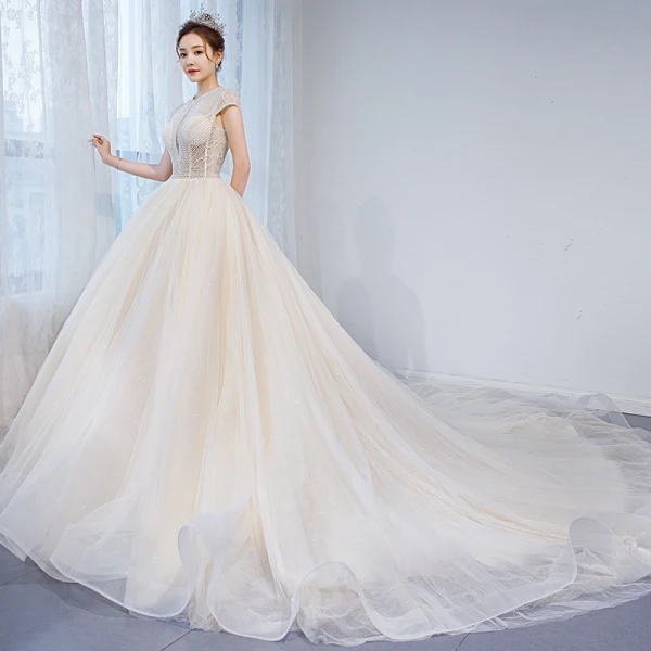 Charmant Champagner Durchsichtige Brautkleider / Hochzeitskleider 2020 Ballkleid Rundhalsausschnitt Ärmel Rückenfreies Perlenstickerei Glanz Tülle Kapelle-Schleppe Rüschen