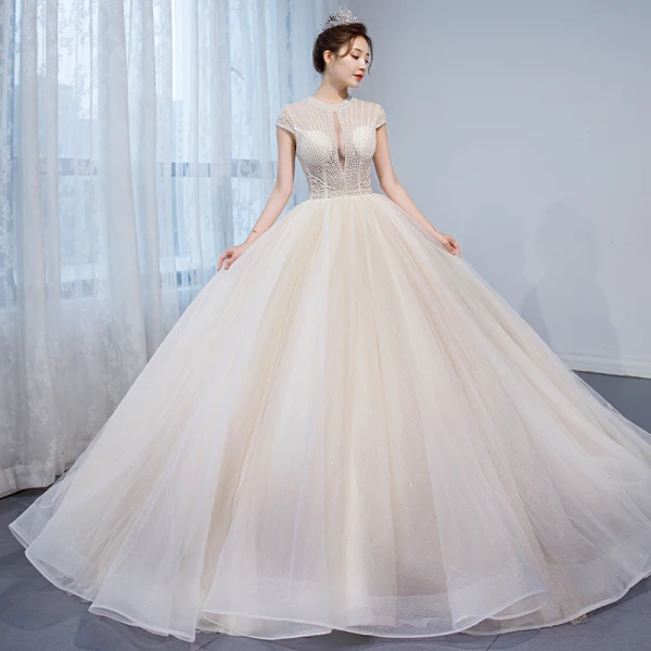 Charmant Champagner Durchsichtige Brautkleider / Hochzeitskleider 2020 Ballkleid Rundhalsausschnitt Ärmel Rückenfreies Perlenstickerei Glanz Tülle Kapelle-Schleppe Rüschen