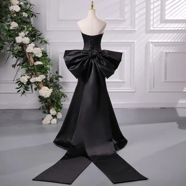 Audrey Hepburn-Stil Schwarz Ballkleider 2024 Meerjungfrau Ärmellos Rückenfreies Schleife Sweep / Pinsel Zug Ball Festliche Kleider