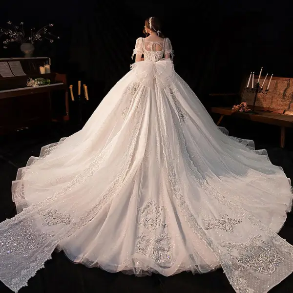 Atemberaubend Ivory / Creme Perlenstickerei Perle Strass Pailletten Spitze Blumen Brautkleider / Hochzeitskleider 2022 Ballkleid Eckiger Ausschnitt Kurze Ärmel Rückenfreies Schleife Kapelle-Schleppe Hochzeit